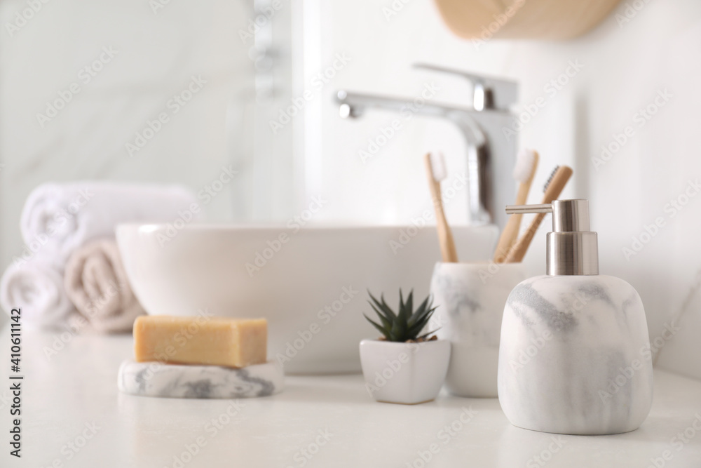 Holder with toothbrushes, plant and different toiletries near vessel sink in bathroom
