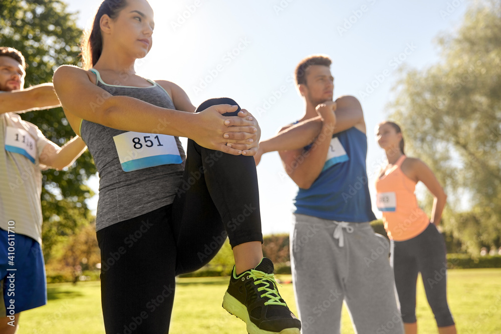 Obraz premium fitness, sport and healthy lifestyle concept - group of people exercising with trainer at summer park