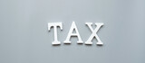 Wooden TAX text on gray background. investment, time to tax, Financial, Management, business and Economic concept