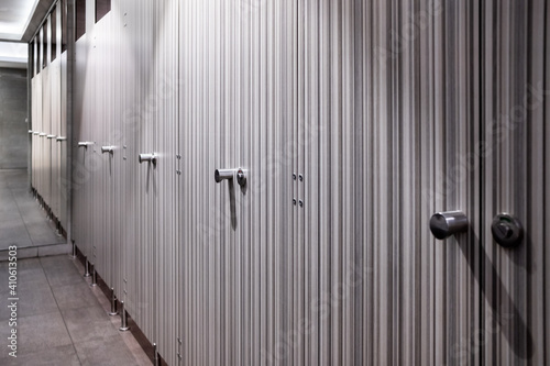 A row of closed toilet cubicle doors in a modern public toilet. Reflection in the mirror. Modern interior design.