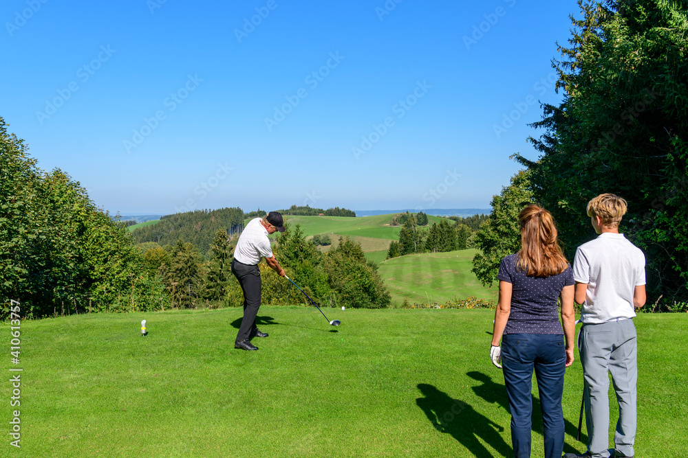 Familien-Flight beim Abschlag auf einem herrlich gelegenen Golfplatz Familien-Flight beim Abschlag auf einem herrlich gelegenen Golfplatz