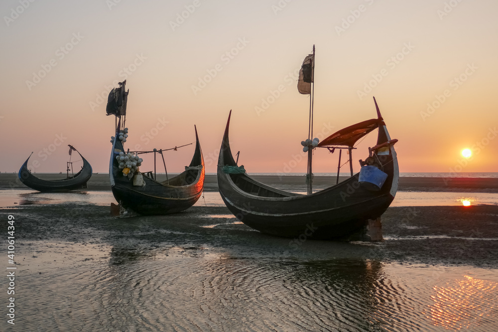 Beautiful traditional wooden fishing boats known as moon boats on beach near Cox's Bazar in southern Bangladesh at sunset