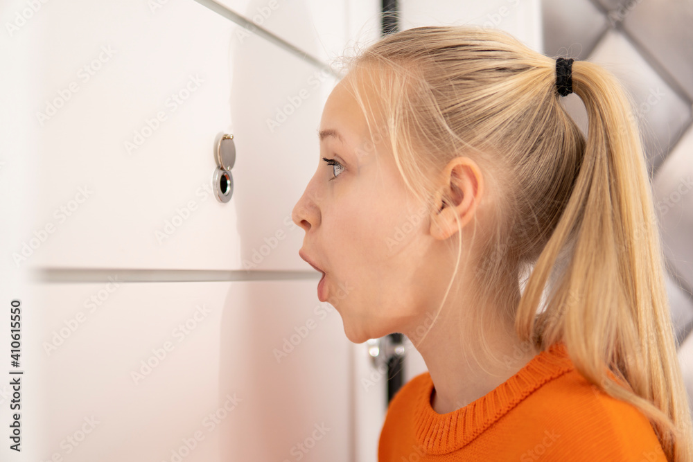 young attractive girl looks through the peephole and laughs young attractive girl looks through the peephole and laughs