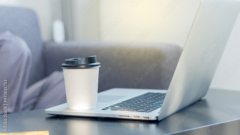 Fototapeta premium A coffee mug on a businessman's laptop for drowsy drinking