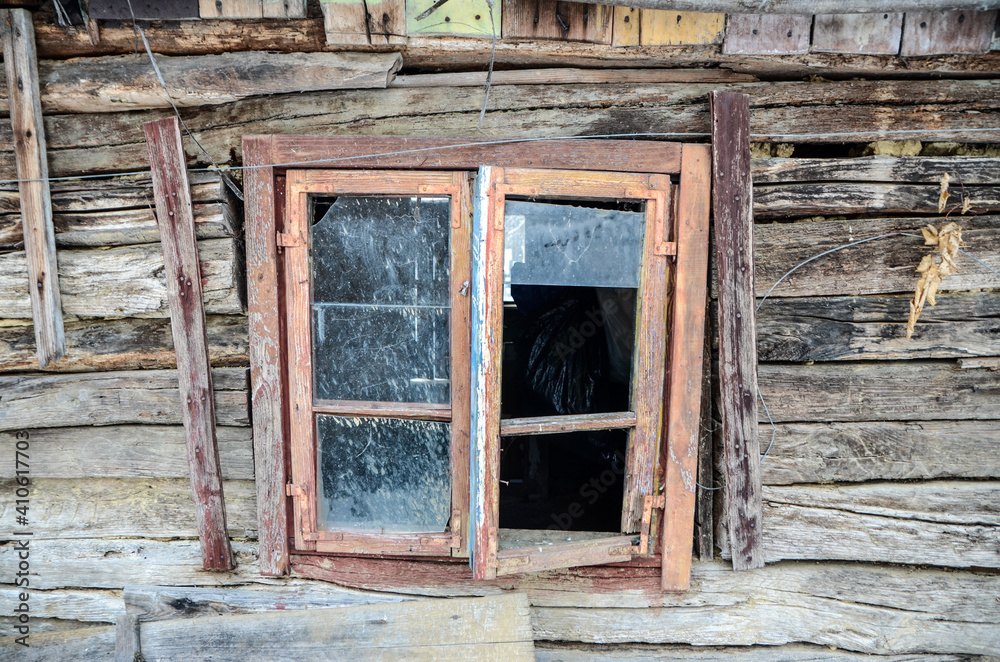 Window on traditional wooden house in village. Old wooden hut covered with a snow in winter. Window on traditional wooden house in village. Old wooden hut covered with a snow in winter.