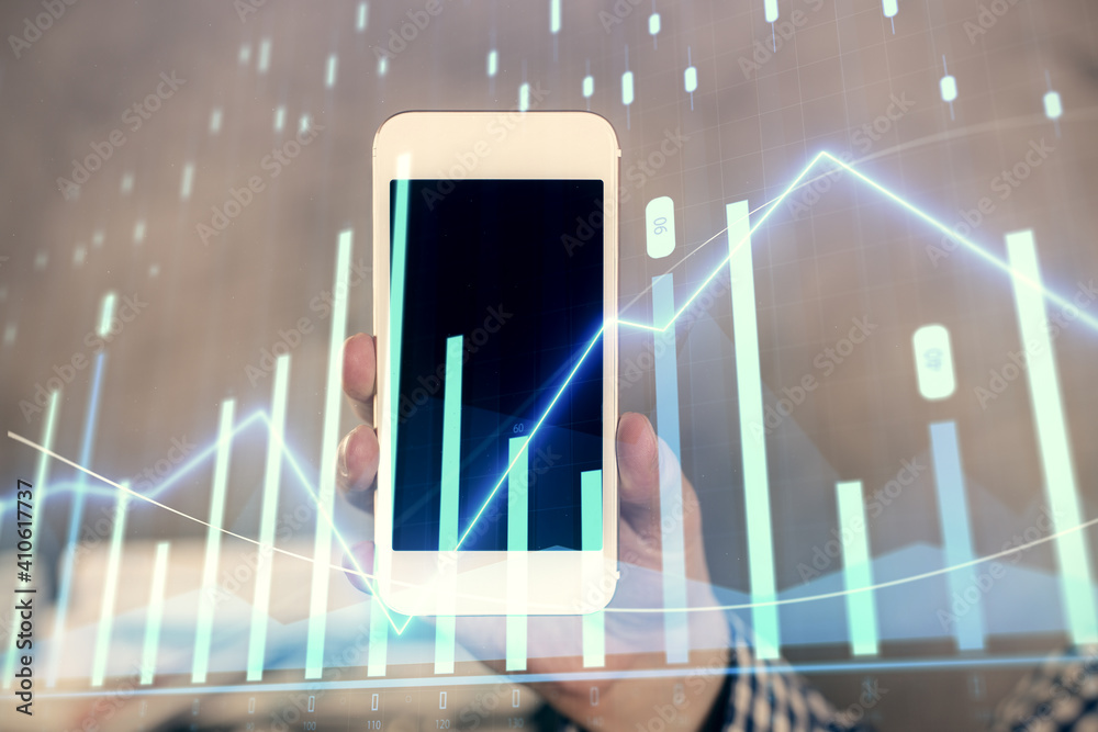 Double exposure of man's hands holding and using a digital device and forex graph drawing. Financial market concept. Double exposure of man's hands holding and using a digital device and forex graph drawing. Financial market concept.