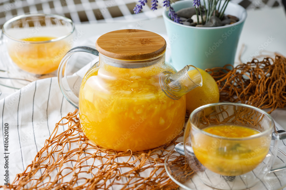 rich teapot of citrus tea with orange and lemon on a light background with two cups of tea rich teapot of citrus tea with orange and lemon on a light background with two cups of tea
