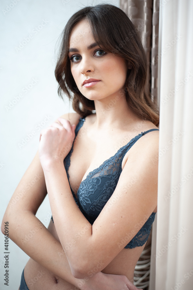  beautiful  young woman with long hair in underwear stands near a window. the concept of the bride's morning and body care.