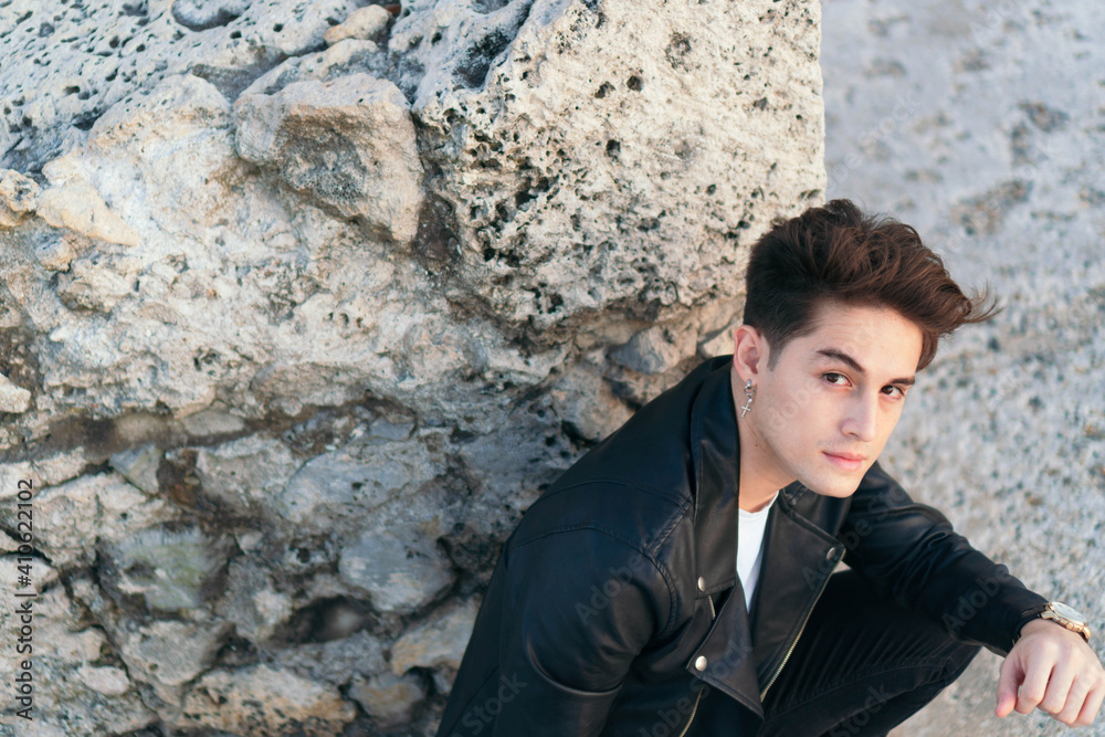 Portrait of a handsome young man outdoors in the city, looking at the camera.