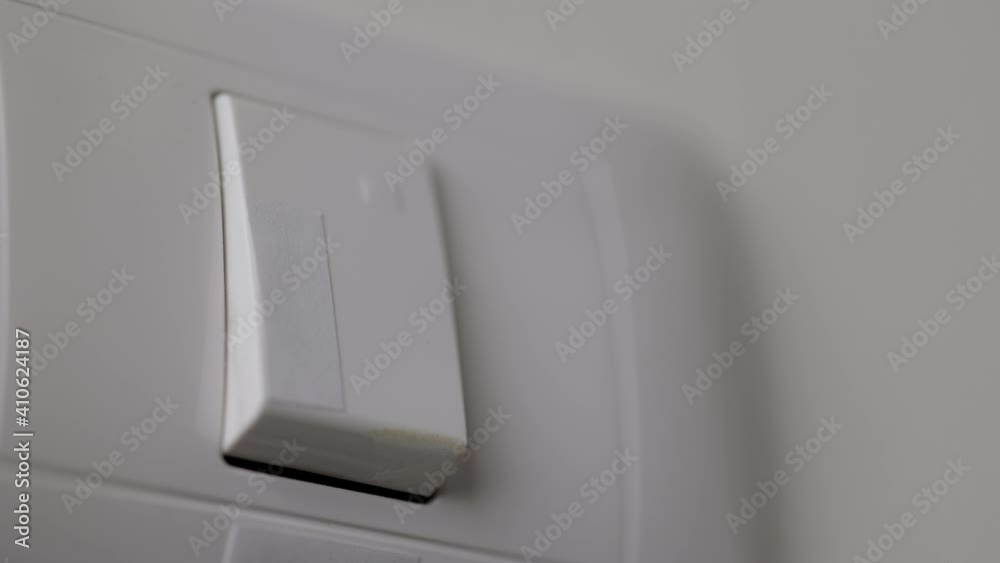Earth Hour, Close up male hand turn off the light to saving electrical energy. Finger pushing light switch turn on or off. White switch Earth Hour, Close up male hand turn off the light to saving electrical energy. Finger pushing light switch turn on or off. White switch