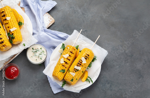 Grilled roasted sweet corn cobs with souces photo