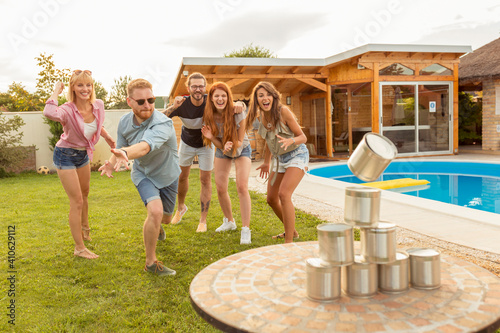 Friends playing knock down tin cans game