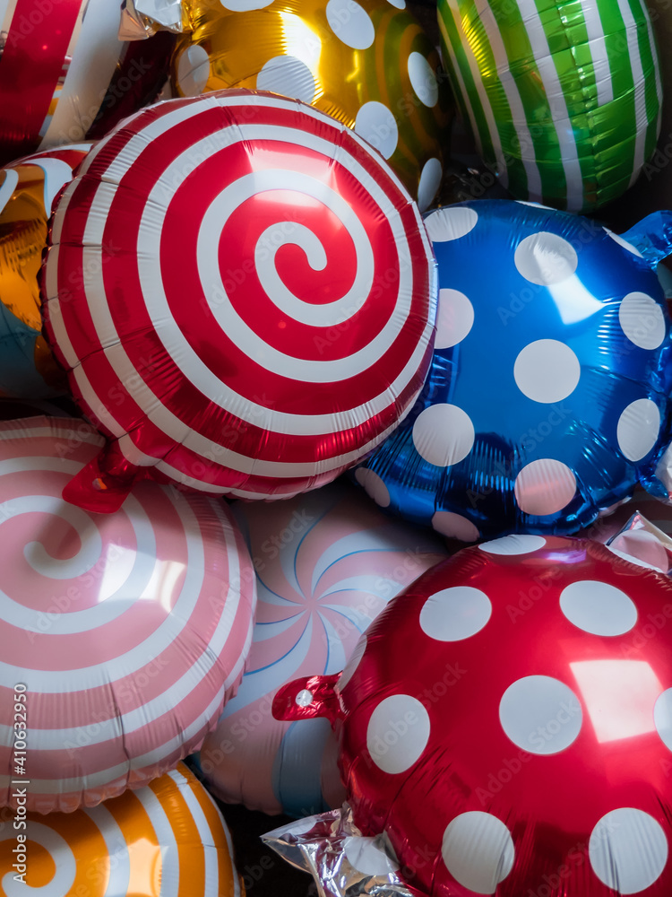 Bright colored round party balloons background with swirls and dots sweet wrappers