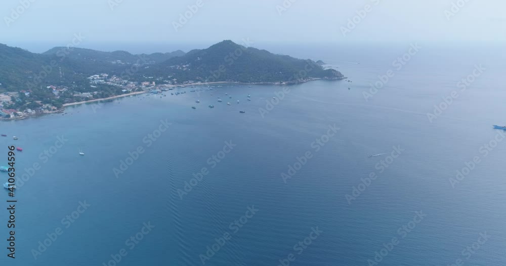 Thailand's harbor aerial: ships, yachts, boats view at Koh Tao Island. Dramatic evening seascape Gulf of Siam on background of small hilly islet in spring. Panoramic footage shot in 4K, UHD Thailand's harbor aerial: ships, yachts, boats view at Koh Tao Island. Dramatic evening seascape Gulf of Siam on background of small hilly islet in spring. Panoramic footage shot in 4K, UHD