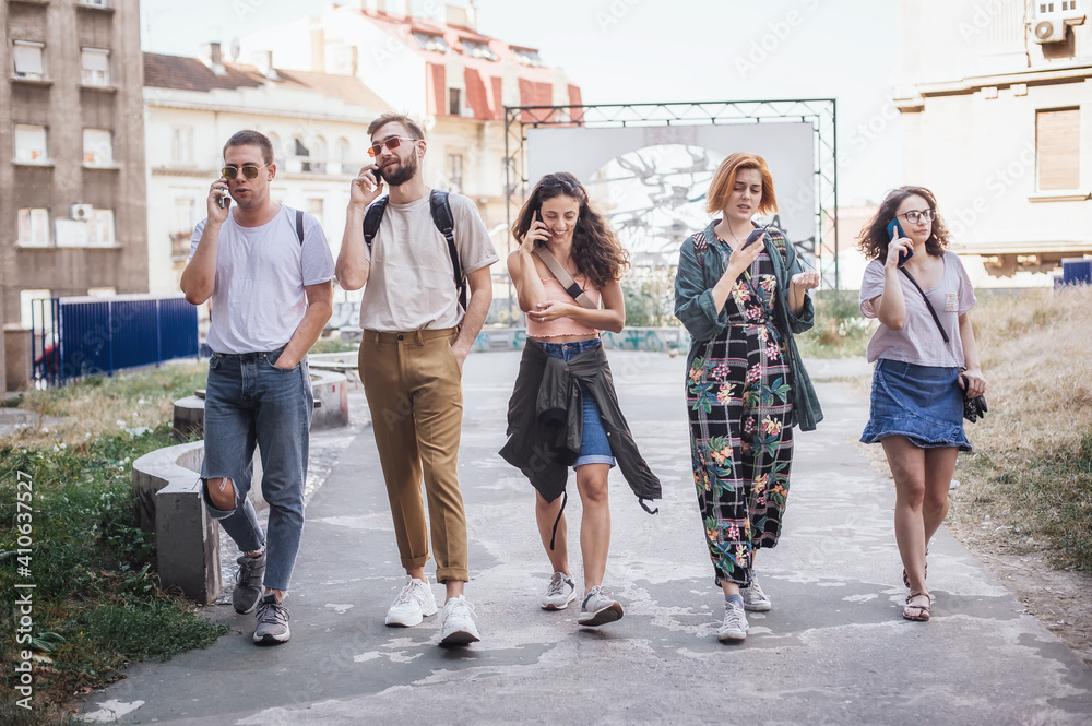 Group of friends using smartphones together. Young people addiction to new technology trends. Youth, new generation internet friendship concept. Emotional isolation and depresion Group of friends using smartphones together. Young people addiction to new technology trends. Youth, new generation internet friendship concept. Emotional isolation and depresion