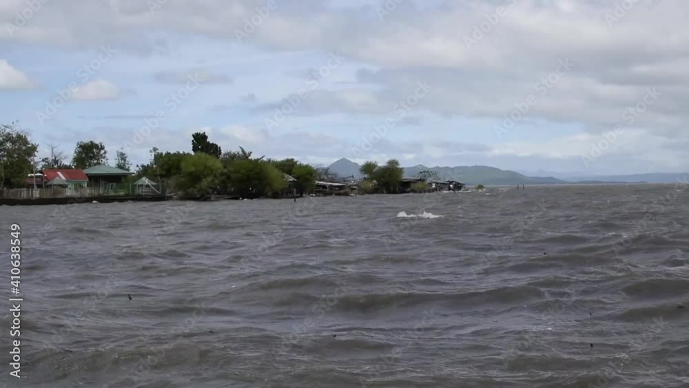 Strong stormy Winds and high tides cause lake water to rise reaching shanty houses along the shore