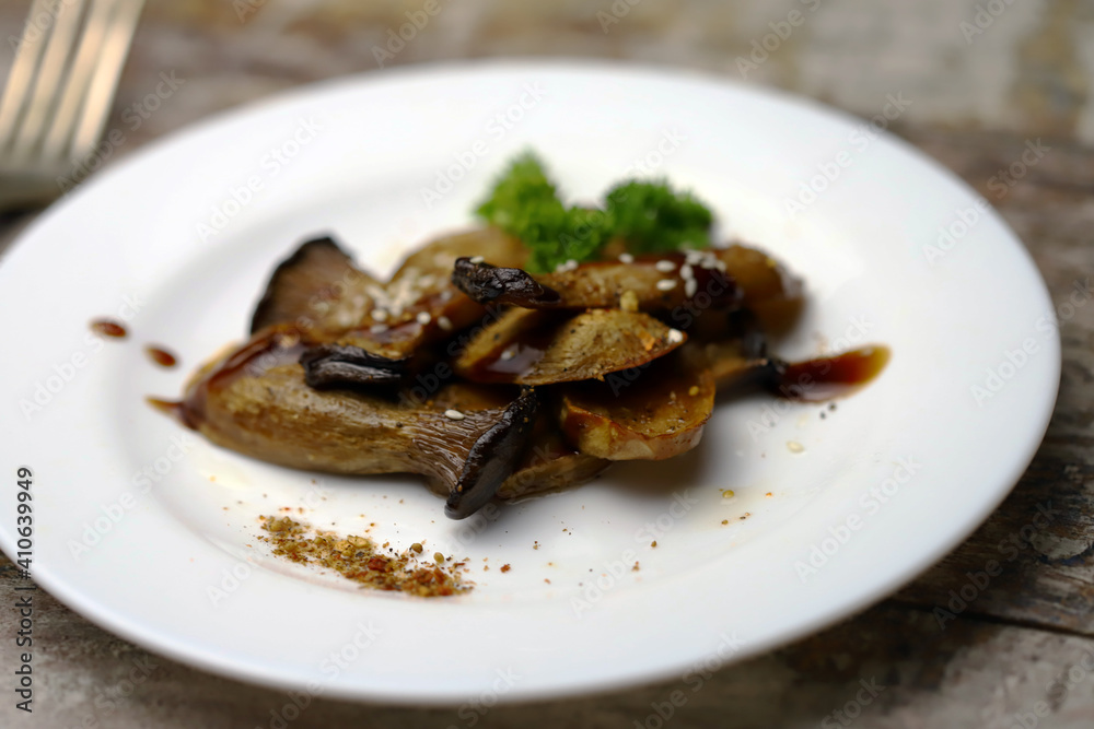 Soft focus. Eringi mushrooms on a plate with spices. Cooked eringi mushrooms.