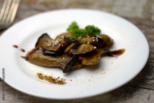 Soft focus. Eringi mushrooms on a plate with spices. Cooked eringi mushrooms.