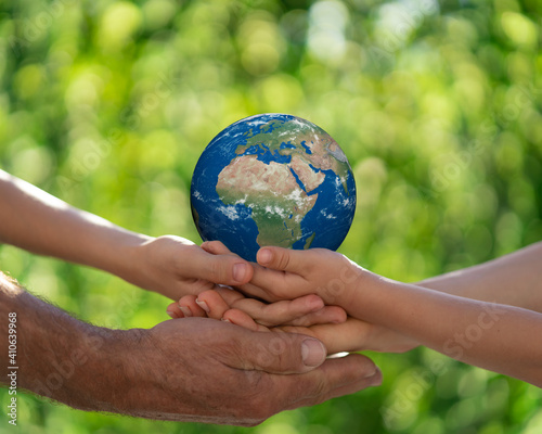 Family holding blue planet in hands. Earth day spring holiday concept. Elements of this image furnished by NASA