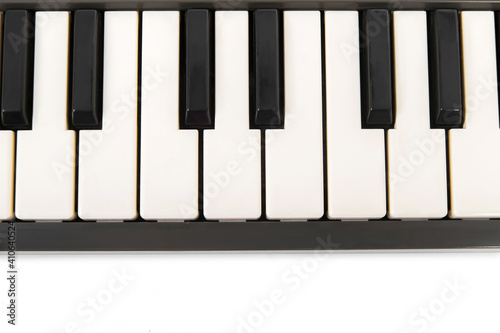 Vista de cerca de las teclas de un teclado de piano electrónico aislado sobre fondo blanco. Imagen horizontal del dispositivo con espacio de copia.