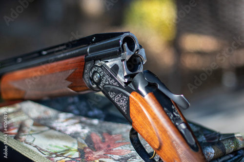 Close-up of an open double-barreled shotgun, soft focus, background blurred