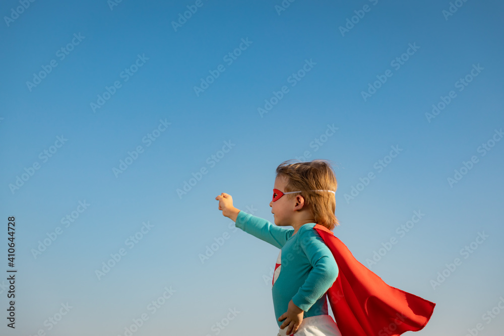 Superhero child against blue summer sky background Superhero child against blue summer sky background