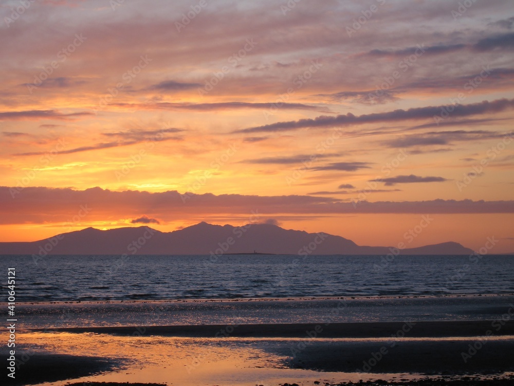Sunset over the Firth of Clyde with the island of Arran silhouetted on the horizon. 