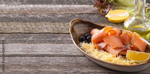 Raw frozen salmon with cheese, lemon and olives. Stroganina. Banner, copy space