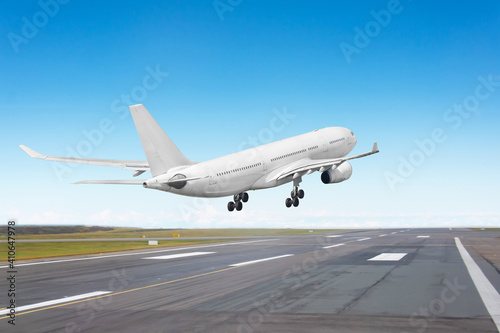 Aircraft landing on the runway, flight before touching the asphalt, rear view to the runway end.