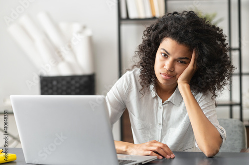 Fotografija Young African American woman with afro hairstyle looks annoyed and stressed, sit