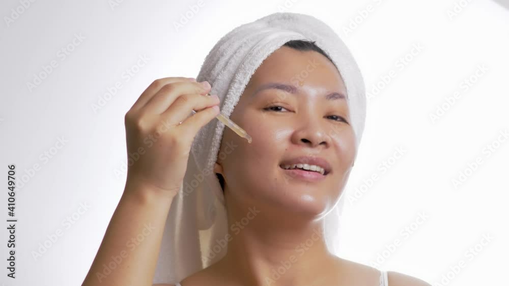 Close up of a woman applying a serum to her face for daily skincare Close up of a woman applying a serum to her face for daily skincare