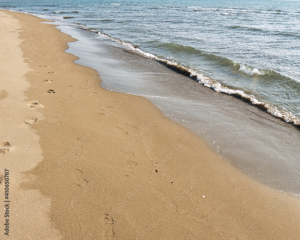 At the shore area, sandy beach and the water of the Adriatic Sea with small waves At the shore area, sandy beach and the water of the Adriatic Sea with small waves