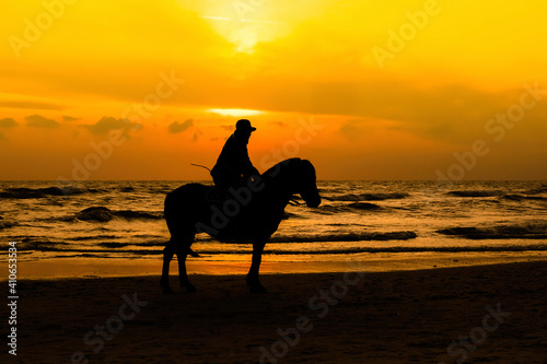 Silhouette of man and horse on Hua Hin beach.