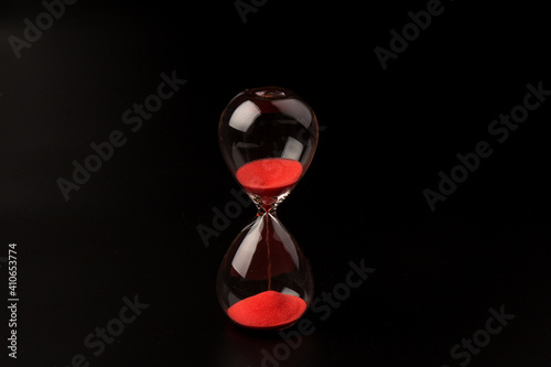 Crystal hourglass on black background as a concept of passing time for business term, urgency and outcome of time.
