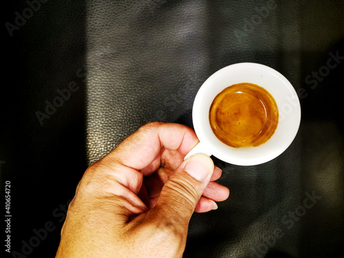 Man holding white cup of hot coffee