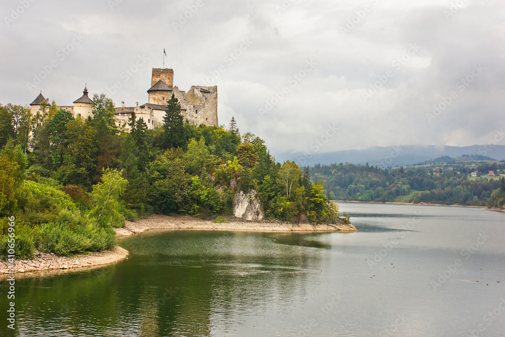 Ancient castle Dunajec in Nedzice, Poland, Europe. Landscape with an old castle on a hill above the lake on a cloudy day. Ancient castle Dunajec in Nedzice, Poland, Europe. Landscape with an old castle on a hill above the lake on a cloudy day.