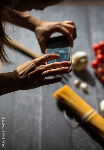 Woman taking food stock photography with her mobile phone.