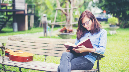 Woman reading book on park bench