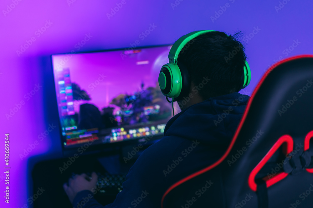 Gamer guy plays computer games. A modern hobby, playing computer games. Side view Gamer guy plays computer games. A modern hobby, playing computer games. Side view