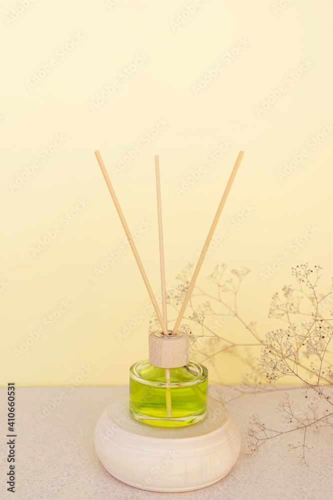 room freshener on a wooden podium on a beige background with delicate flowers. Copy space room freshener on a wooden podium on a beige background with delicate flowers. Copy space