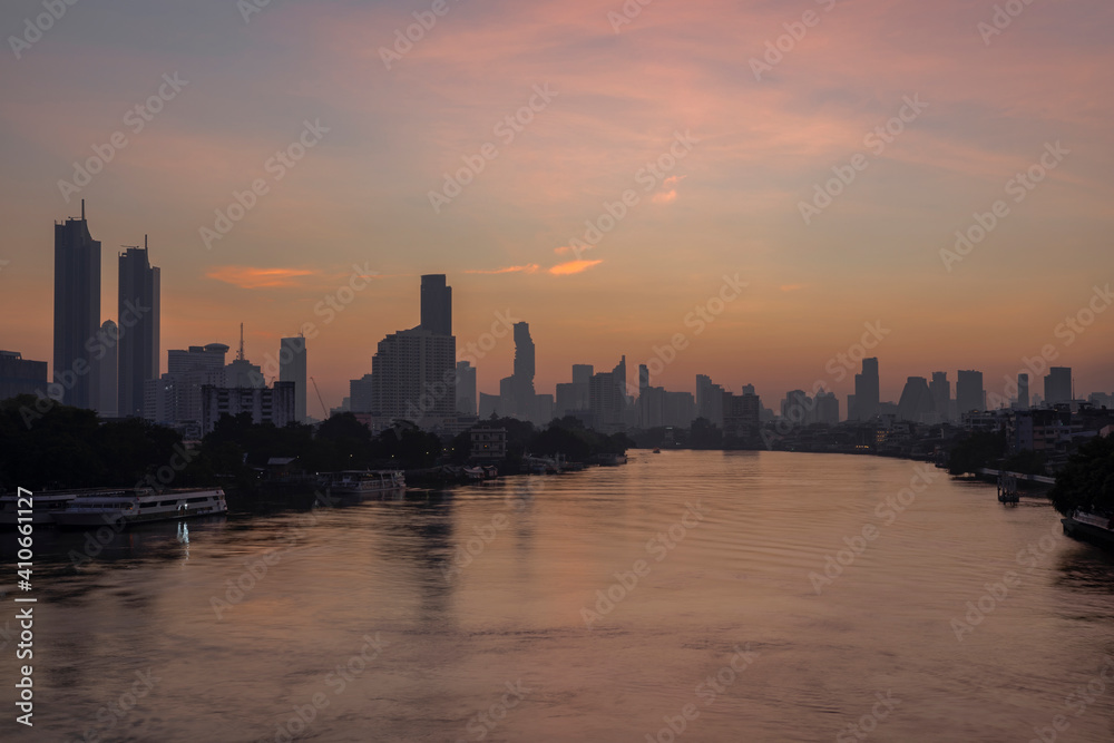 Beautiful landscape of business city with river ferry boat at twilight.