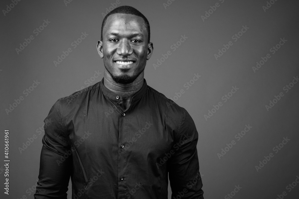 Handsome African businessman against brown background shot in black and white Handsome African businessman against brown background shot in black and white