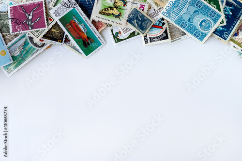 Top border made of multicolored postage stamps collection from different countries on white background