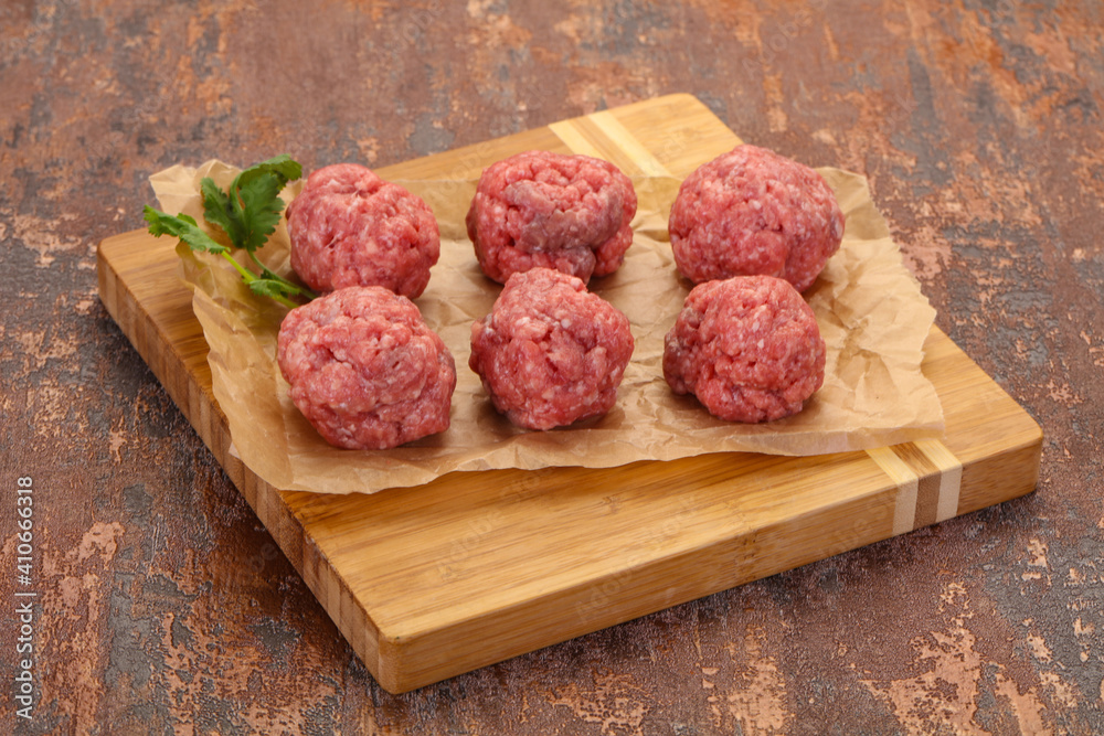 Raw meatball over wooden background Raw meatball over wooden background