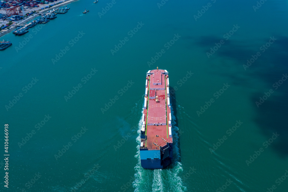 Aerial view ro-ro ship loading new cars. Automotive container carriers sailing on the sea