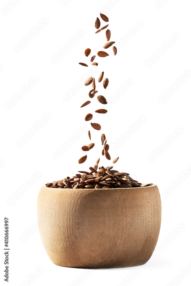 Side view of small wooden bowl filling with linseed or flax seed falling down and isolated on white background - obrazy, fototapety, plakaty 