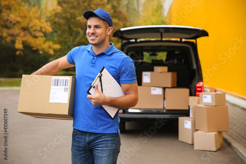 Courier with clipboard and parcel near delivery van outdoors. Space for text photo