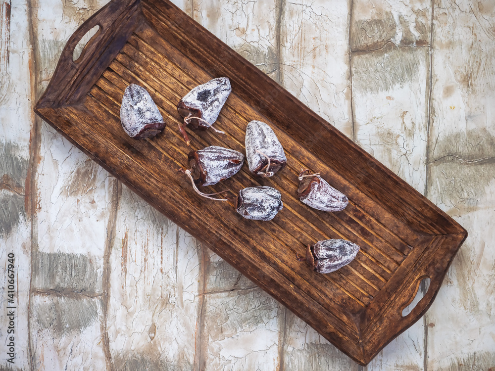 Dried persimmon on a long wooden tray on a light table Dried persimmon on a long wooden tray on a light table