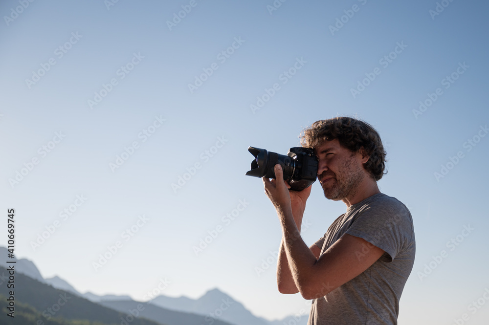 Young man taking photos with professional dslr camera
