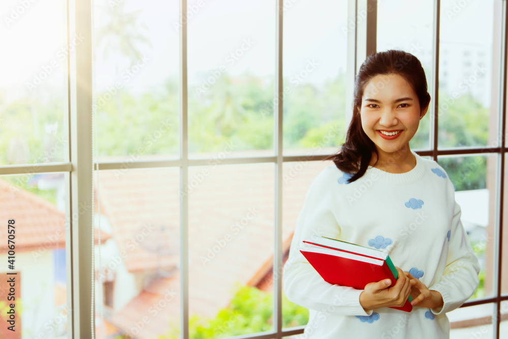 Young people at home studying, online education during outbreak and prevention of COVID-19, looking at camera, smiling cheerful Young people at home studying, online education during outbreak and prevention of COVID-19, looking at camera, smiling cheerful